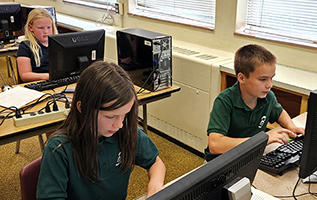 Students practice keyboarding skills in a computer lab.