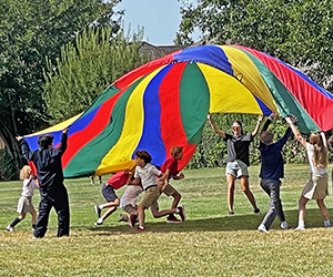 Students play parachute games in the Mini-mini Olympics.