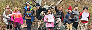 Students pose in front of a bull moose statue at the Red Butte Garden.